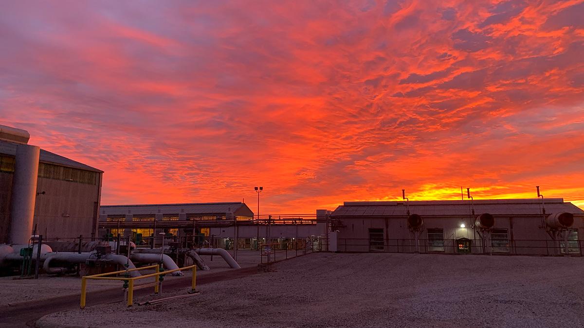 A natural gas facility with a colorful sky
